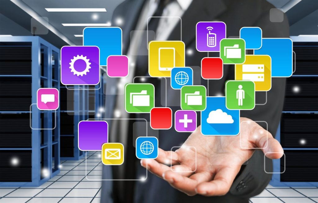 Mano sosteniendo iconos digitales de aplicaciones y servicios en red.