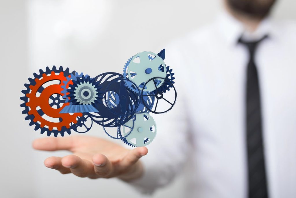 Engranajes digitales sobre mano simbolizando automatización y procesos.