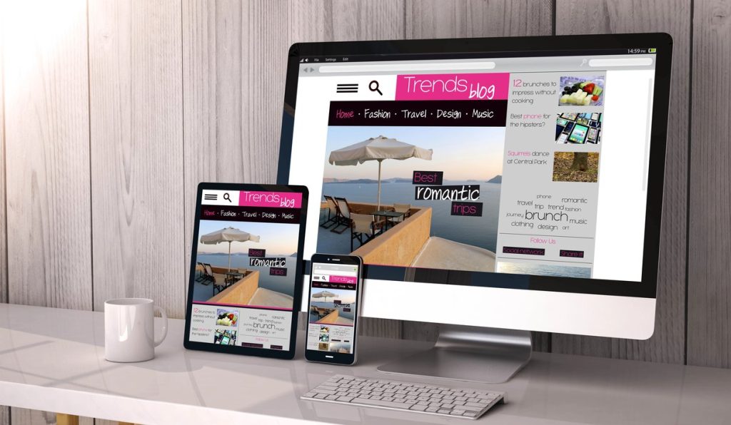 Sitio web visualizado en desktop, tablet y smartphone en entorno de trabajo.